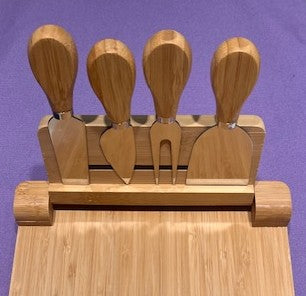 Set of 4 bamboo cheese knives in a bamboo holder on a purple background.