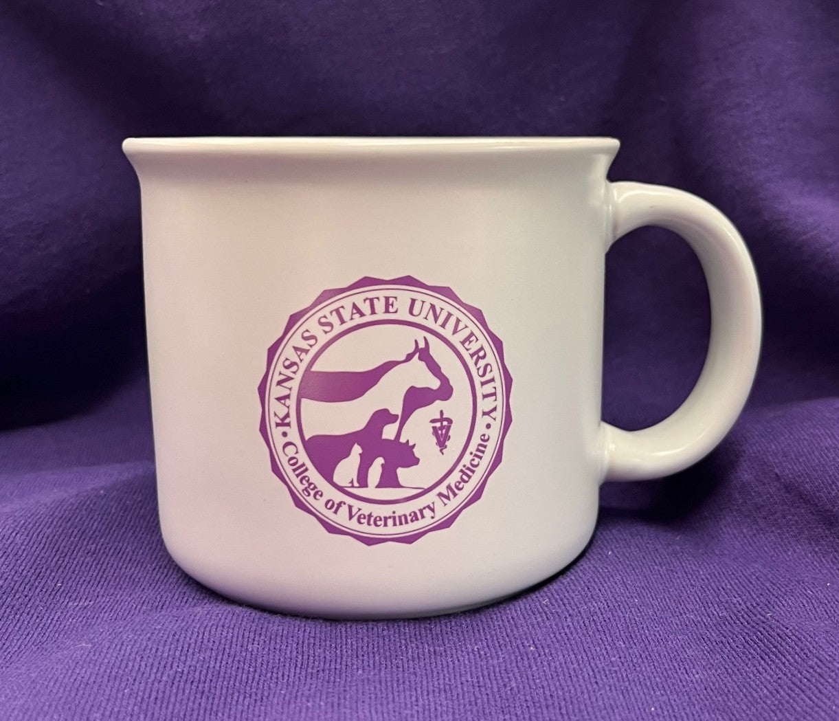 White mug with a purple Kansas State University College of Veterinary Medicine logo against a purple background.