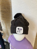 A chunky knit beanie with pom-pom on a mannequin head, featuring a labcoat Willie patch on the cuff.