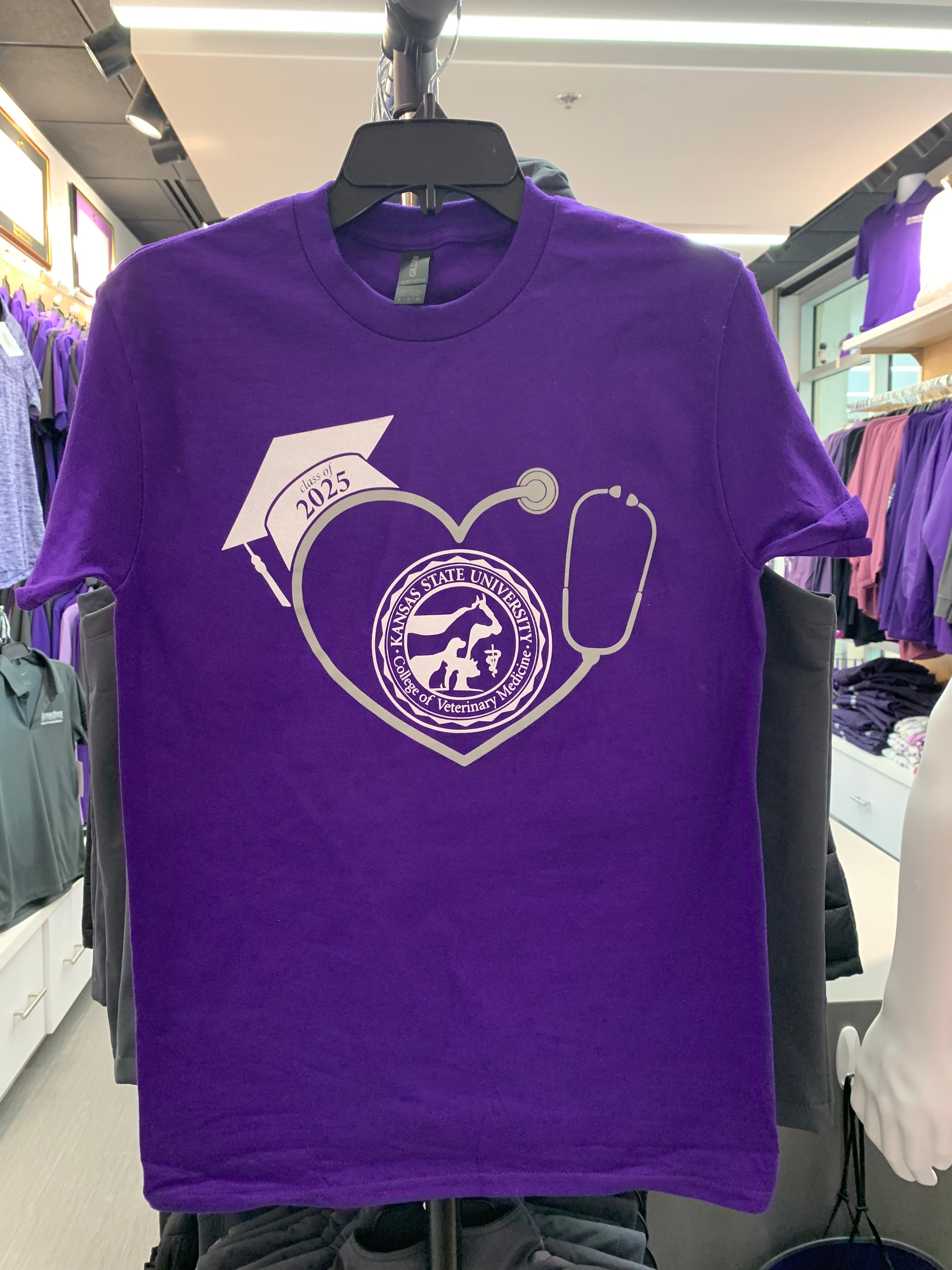 A purple Class of 2025 Graduation T-Shirt with a graphic design of a graduation cap and a stethoscope forming a heart shape with the CVM seal in the center. 