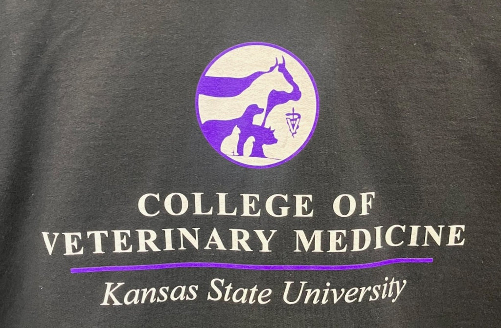 Black shirt with purple and white CVM seal and text for Kansas State University College of Veterinary Medicine.