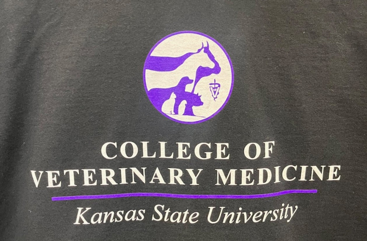 Black shirt with purple and white CVM seal and text for Kansas State University College of Veterinary Medicine.