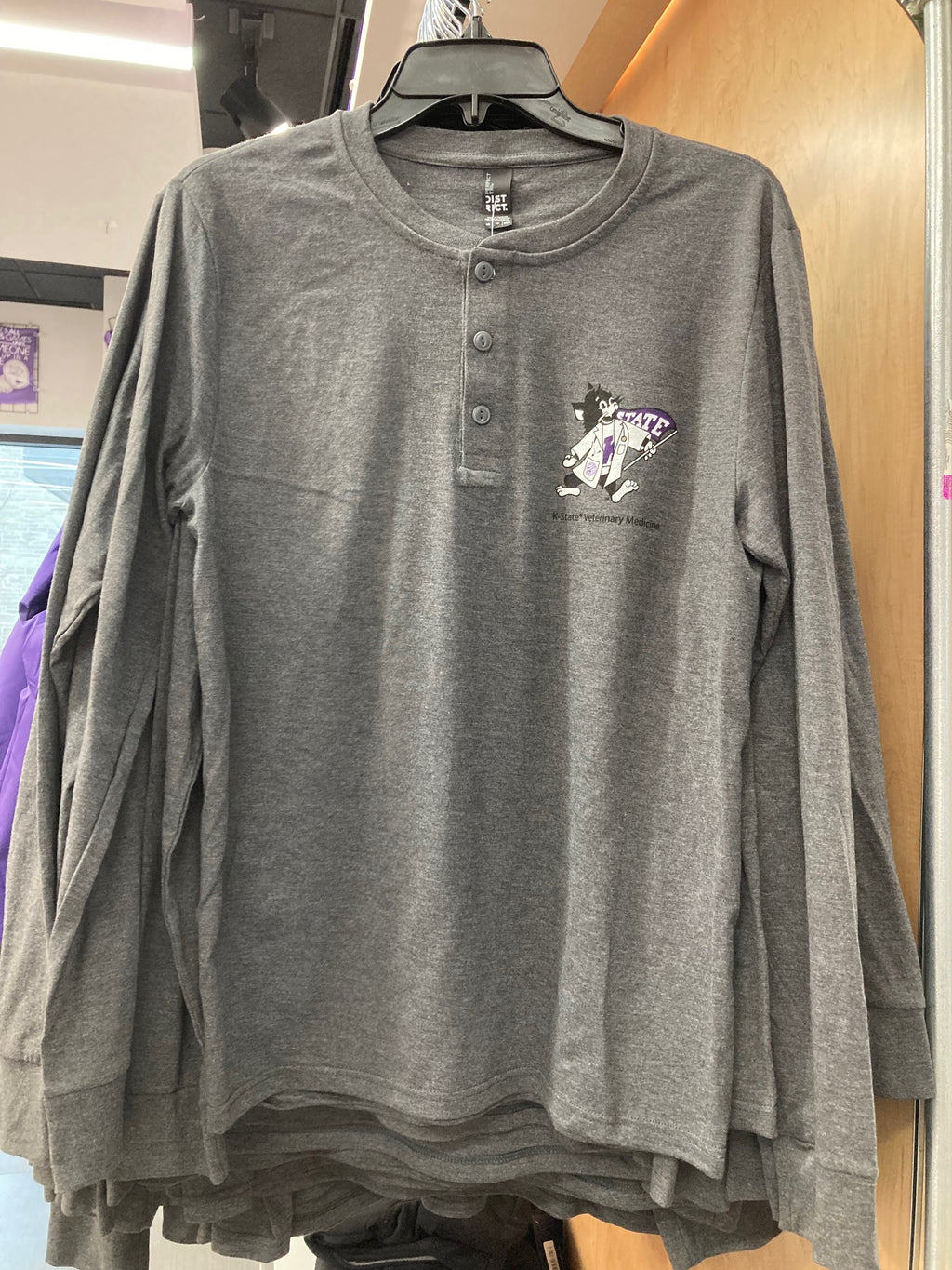 Stacked heathered gray long sleeve Henley shirts on a display rack with a small Labcoat Willie graphic logo on the left chest.