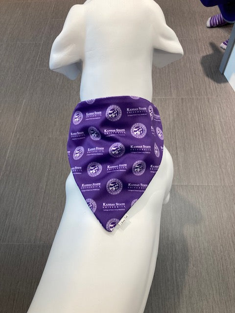 A dark purple dog bandana with the CVM seal and K-State logo making up the alternating pattern across the bandana. 