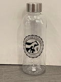 A clear plastic water bottle with a metal screw cap, featuring a black and white CVM seal. 