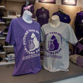 Two Fruit of the Loom t-shirts on display, one in purple and one in gray, both with the text "Future Vets Helping Future Pets" and a K-State Shelter Medicine and Community Outreach Program logo.