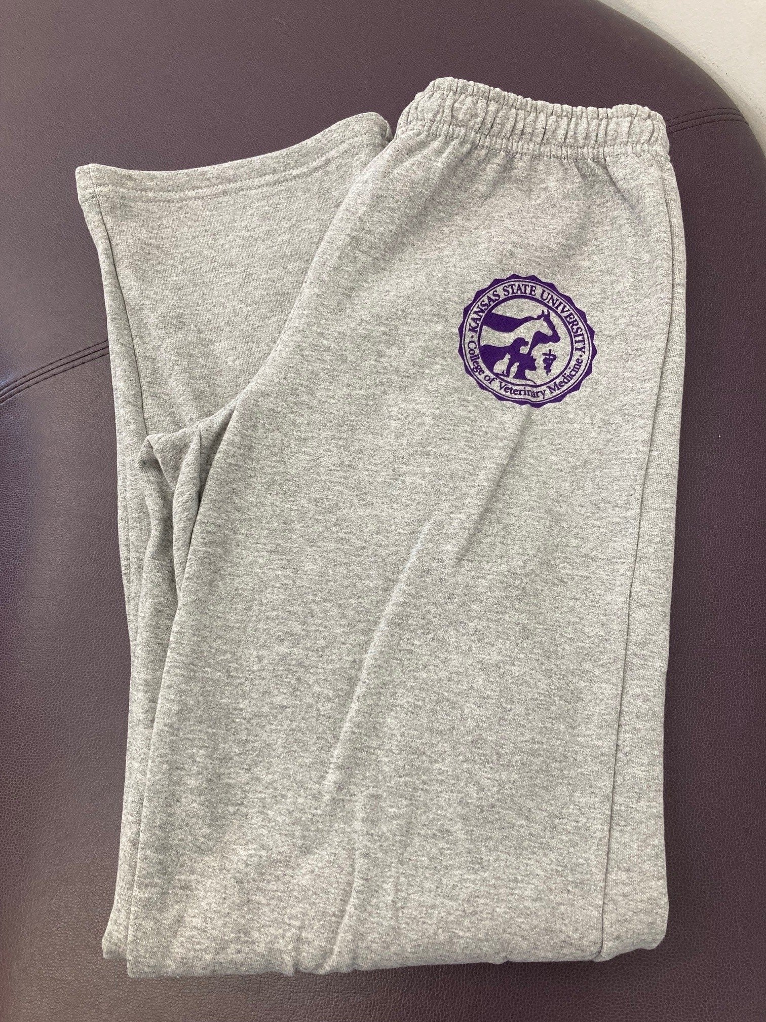 Customized Gildan Heavy Blend Open Bottom Sweatpants in Sports Grey with a purple CVM seal on the upper left thigh.