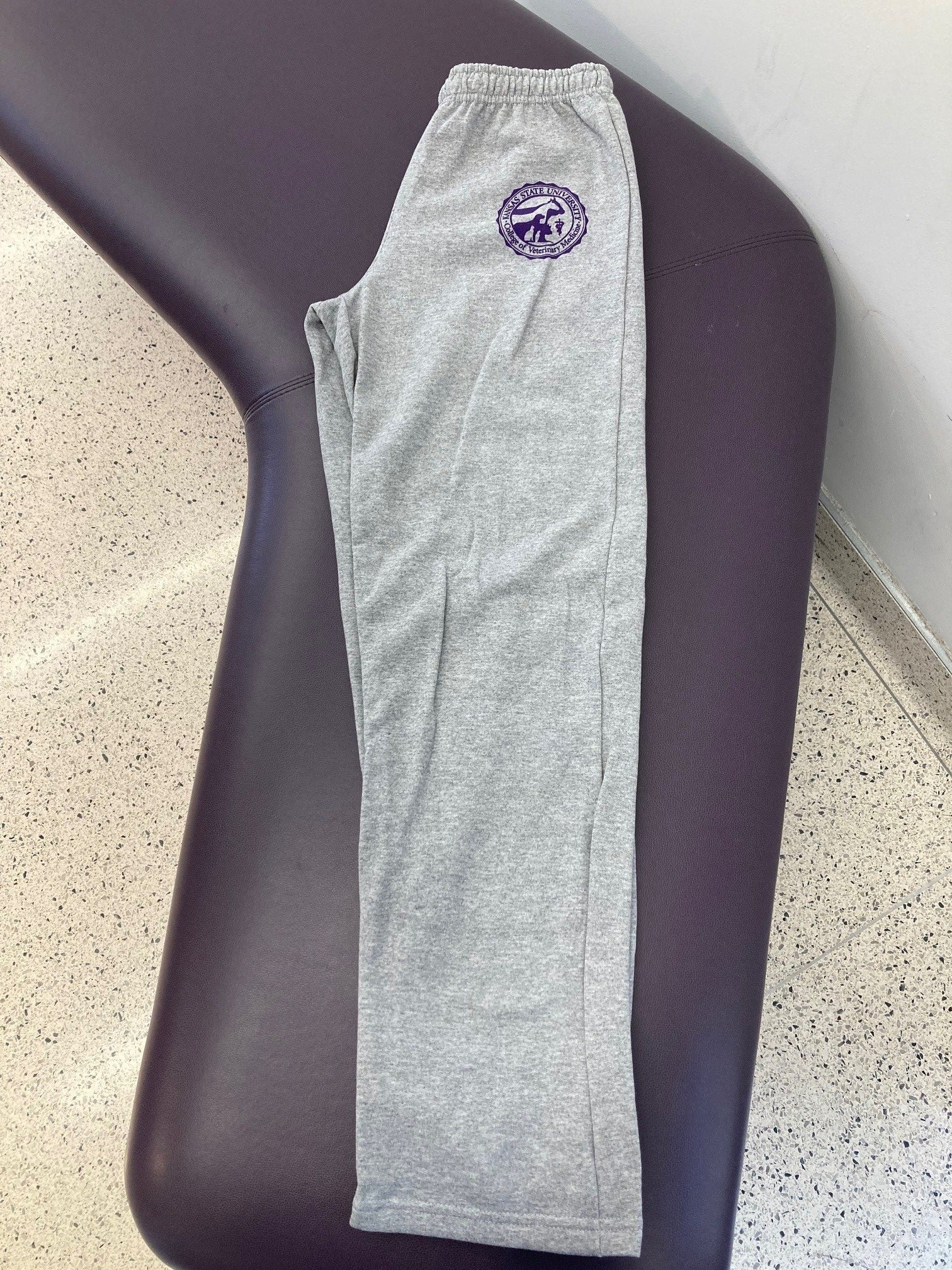 Customized Gildan Heavy Blend Open Bottom Sweatpants in Sports Grey with a purple CVM seal on the upper left thigh.