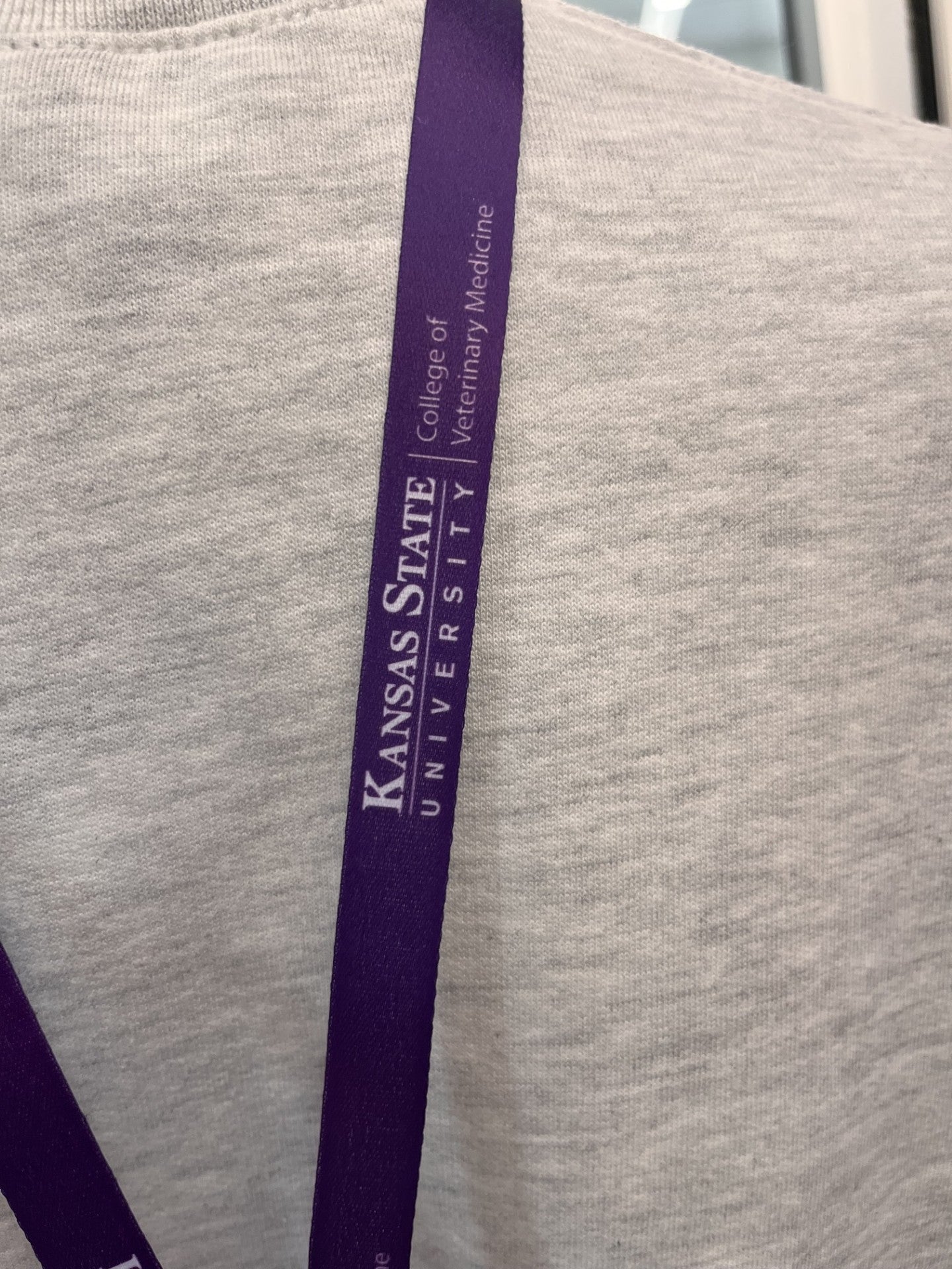 Close-up of the purple lanyard with the text 'Kansas State University College of Veterinary Medicine'.