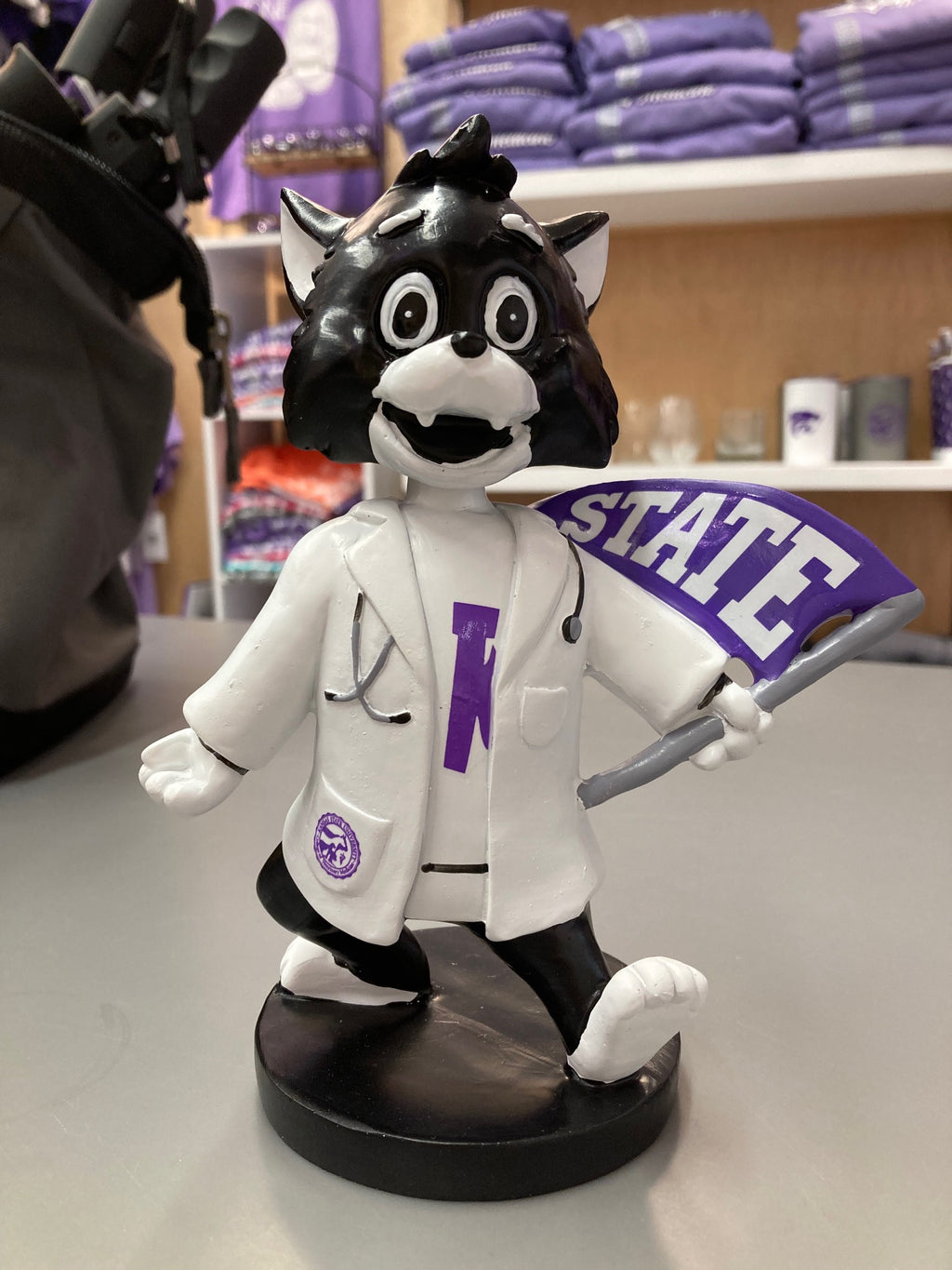A customized Labcoat Willie Bobble Head wearing a white lab coat with a 'STATE' flag element, seated on a bobblehead base.