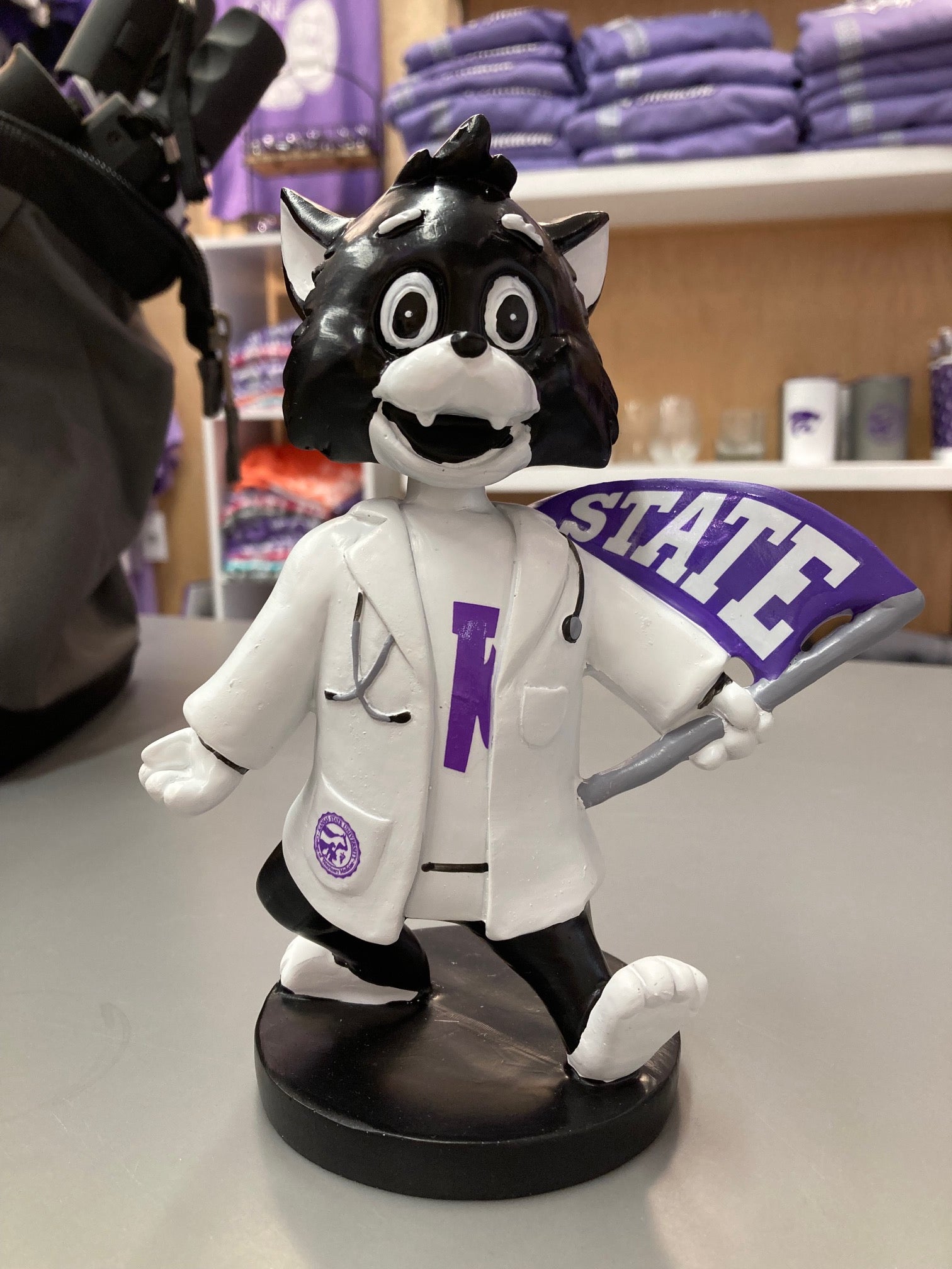 A customized Labcoat Willie Bobble Head wearing a white lab coat with a 'STATE' flag element, seated on a bobblehead base.