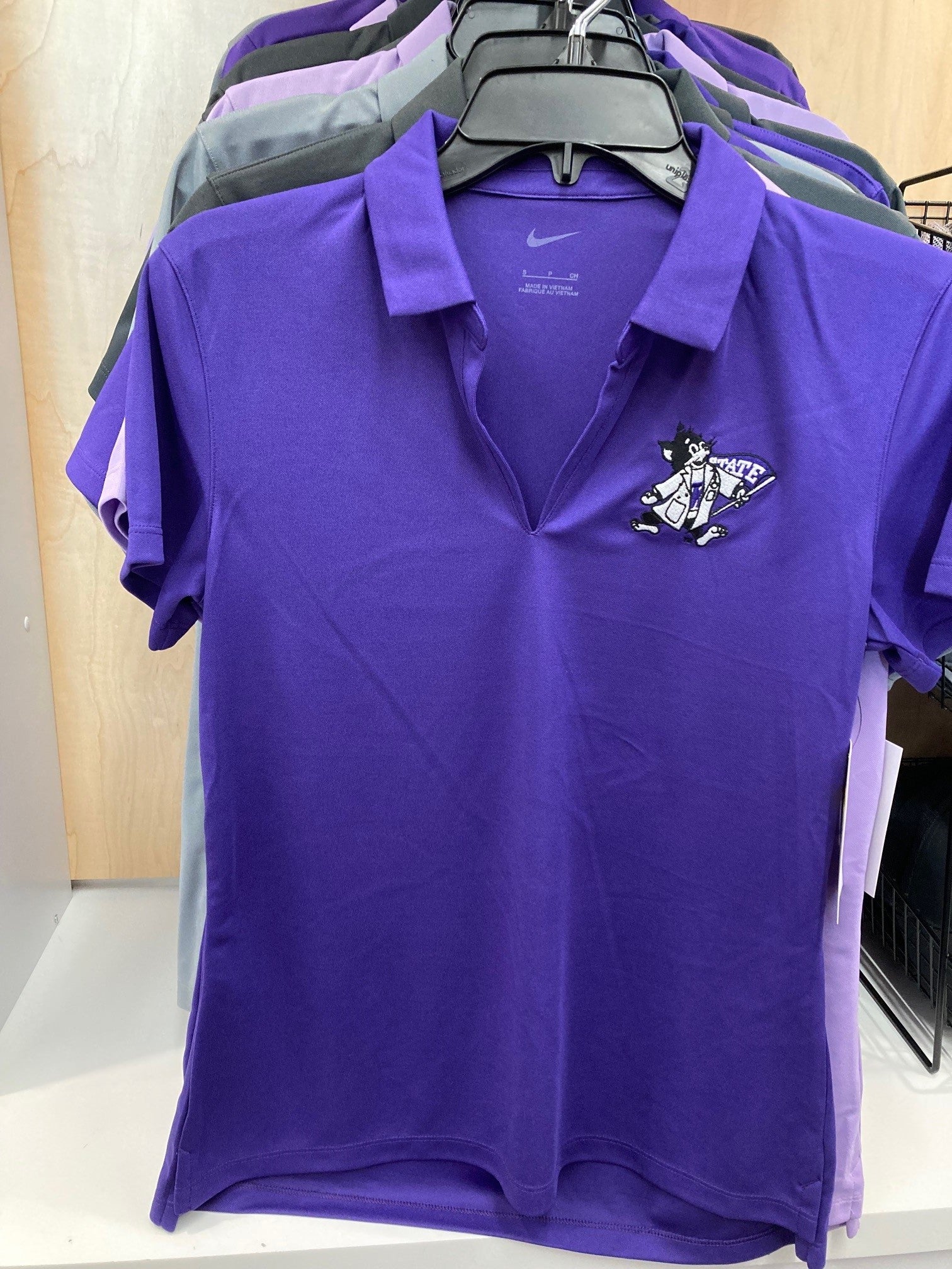 A purple Nike ladies polo shirt with a V-neck and vertical mesh pattern, featuring Labcoat Willie on the upper left chest.