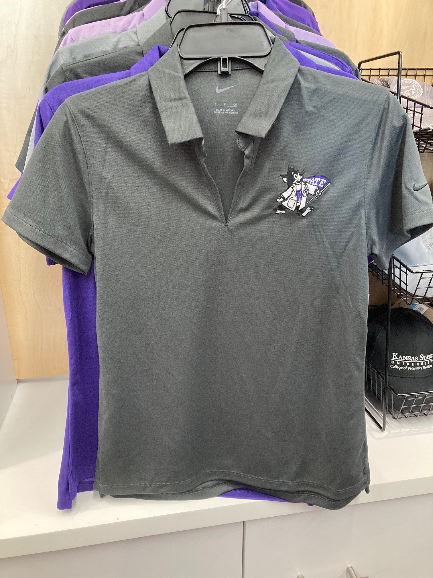A gray Nike ladies polo shirt with a V-neck and vertical mesh pattern, featuring Labcoat Willie on the upper left chest.