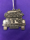 A pewter Christmas ornament with a vintage truck design with '2023' and 'Kansas State University' text on it.