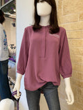A mannequin displaying a purple 3/4 sleeve tunic with a round neckline, half button up option, a white K-State CVM logo on the left chest, and textured fabric.