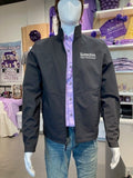 A mannequin wearing a black Port Authority Collective Soft Shell Jacket with a collar and white K-State CVM logo, displayed in a retail setting.