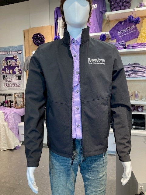 A mannequin wearing a black Port Authority Collective Soft Shell Jacket with a collar and white K-State CVM logo, displayed in a retail setting.