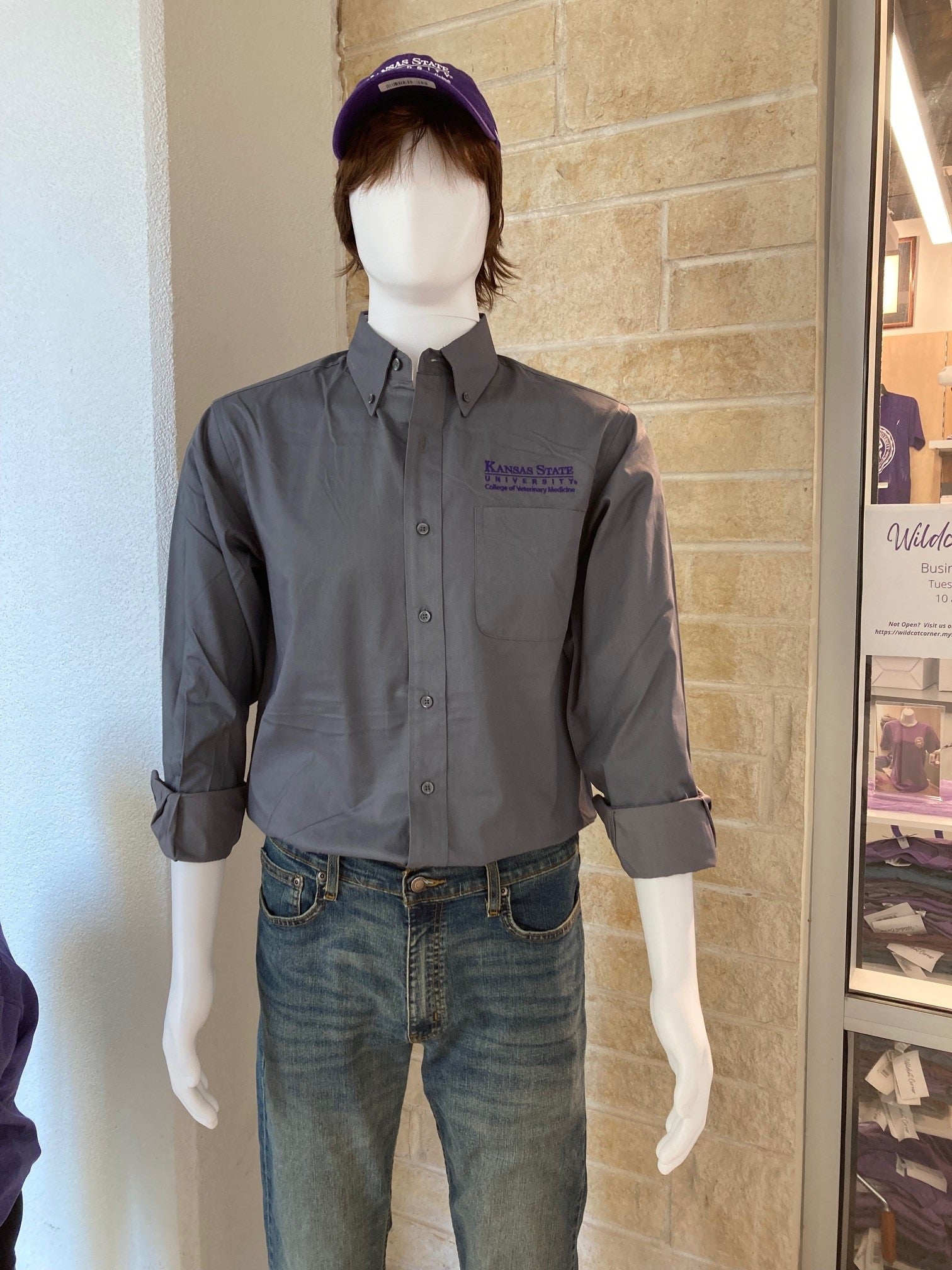 A mannequin wearing a long sleeve steel grey dress shirt with the dark purple K-State CVM logo on the upper right chest.