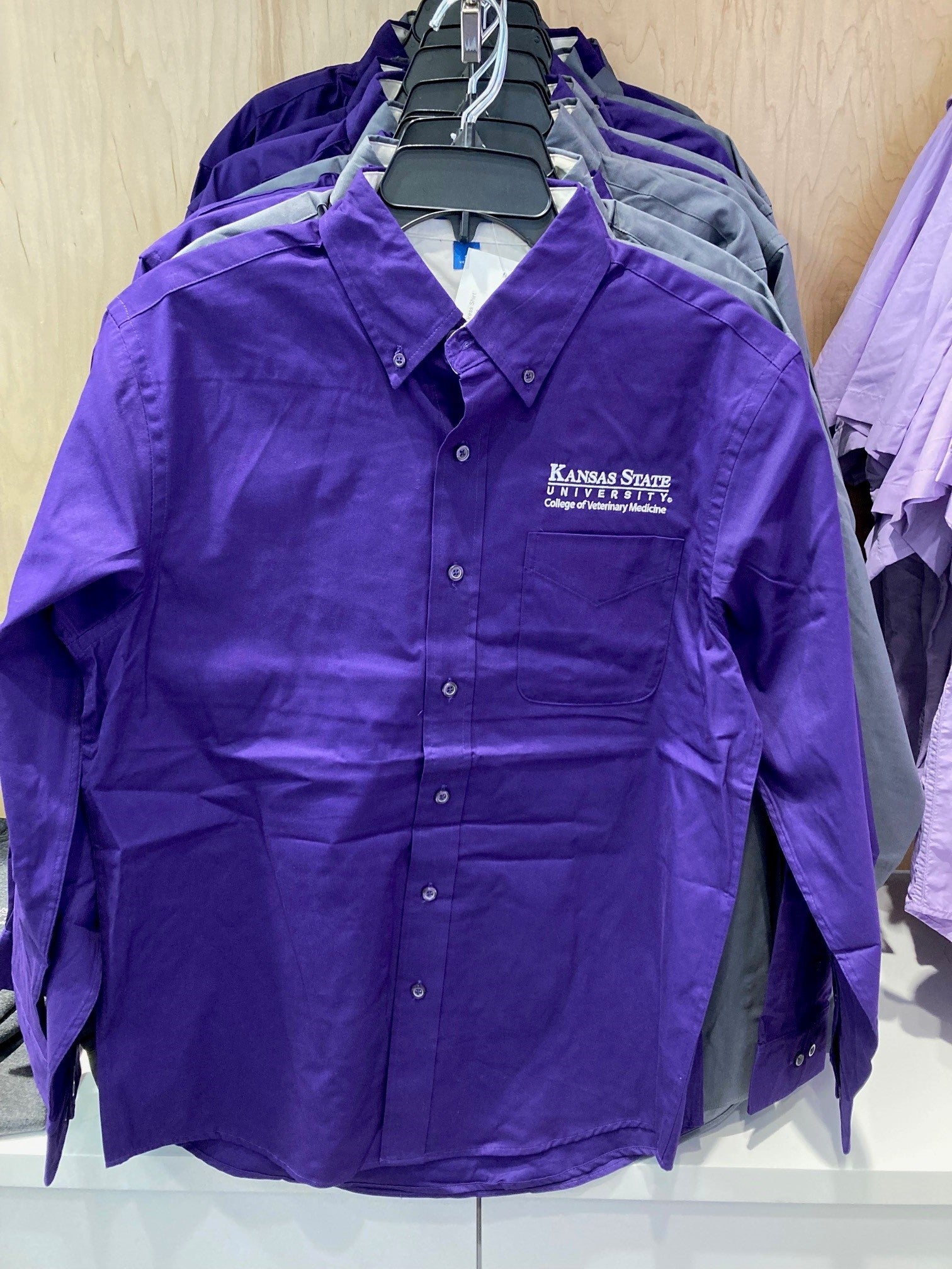 A long sleeve purple dress shirt with the white K-State CVM logo on the upper right chest.