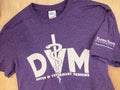 A purple Port & Co. t-shirt with white text that reads "DVM Doctor of Veterinary Medicine" with a white K-State CVM logo on the left sleeve. 