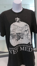 A Port & Company t-shirt featuring a custom design by Ariana Van Pelt, displayed on a mannequin. The shirt is black with text that reads 'Kansas State University VET MED'.