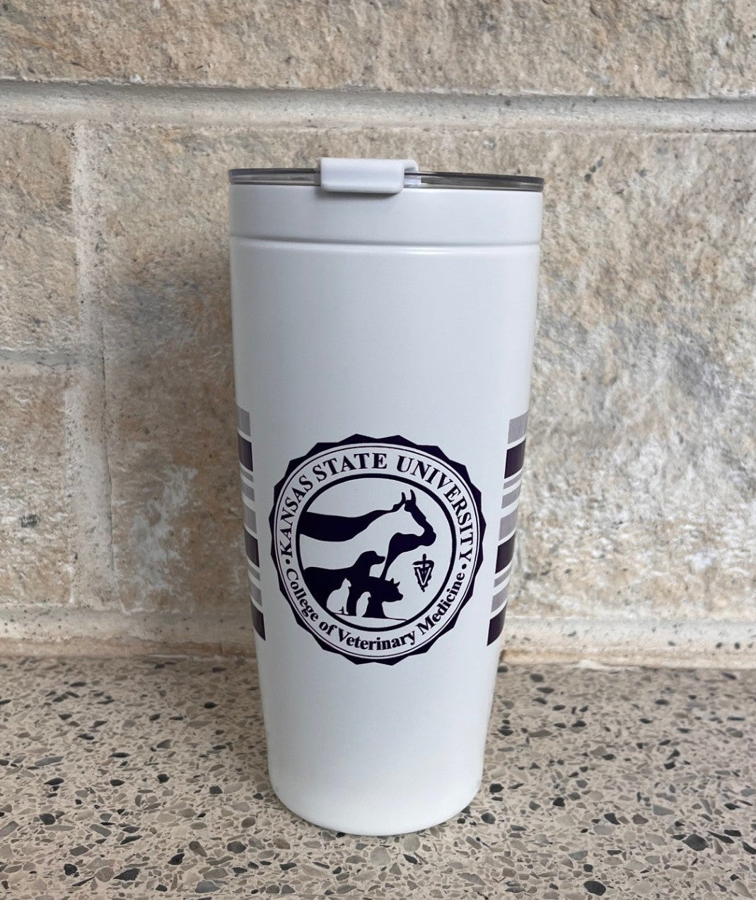 White tumbler with a purple CVM seal and purple striping. 