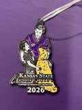 A close-up of a Christmas Ornament with  a silver cord. A little boy with a Veterinarian and a yellow lab with Kansas State University College of Veterinary Medicine logo with the year 2026 in white. 