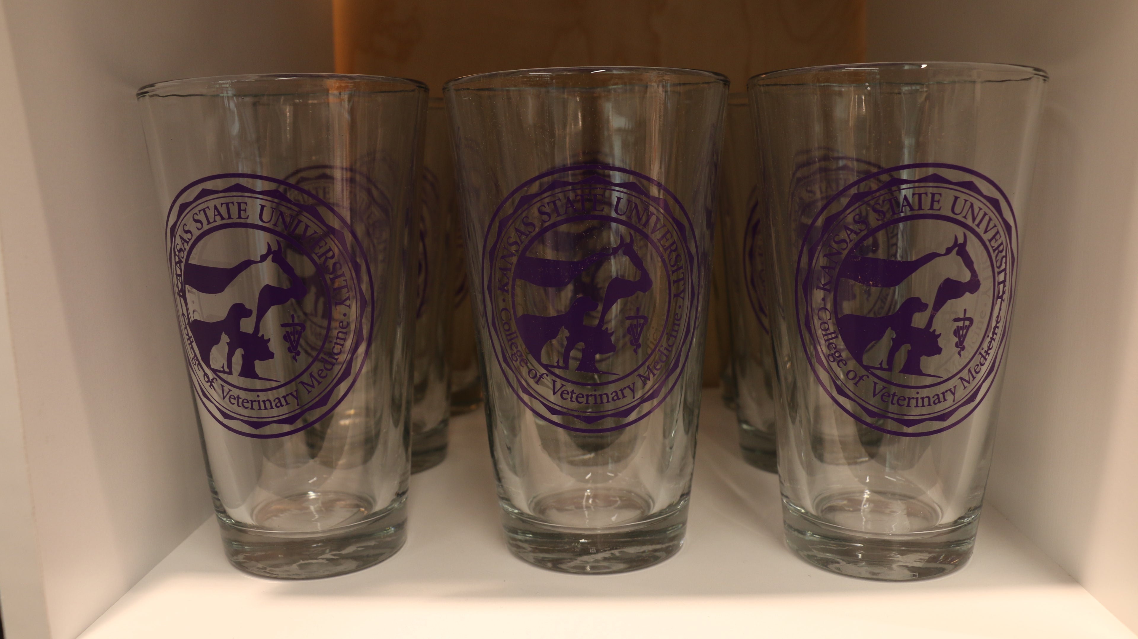 A set of clear executive pint glasses with the purple CVM seal in the center. 