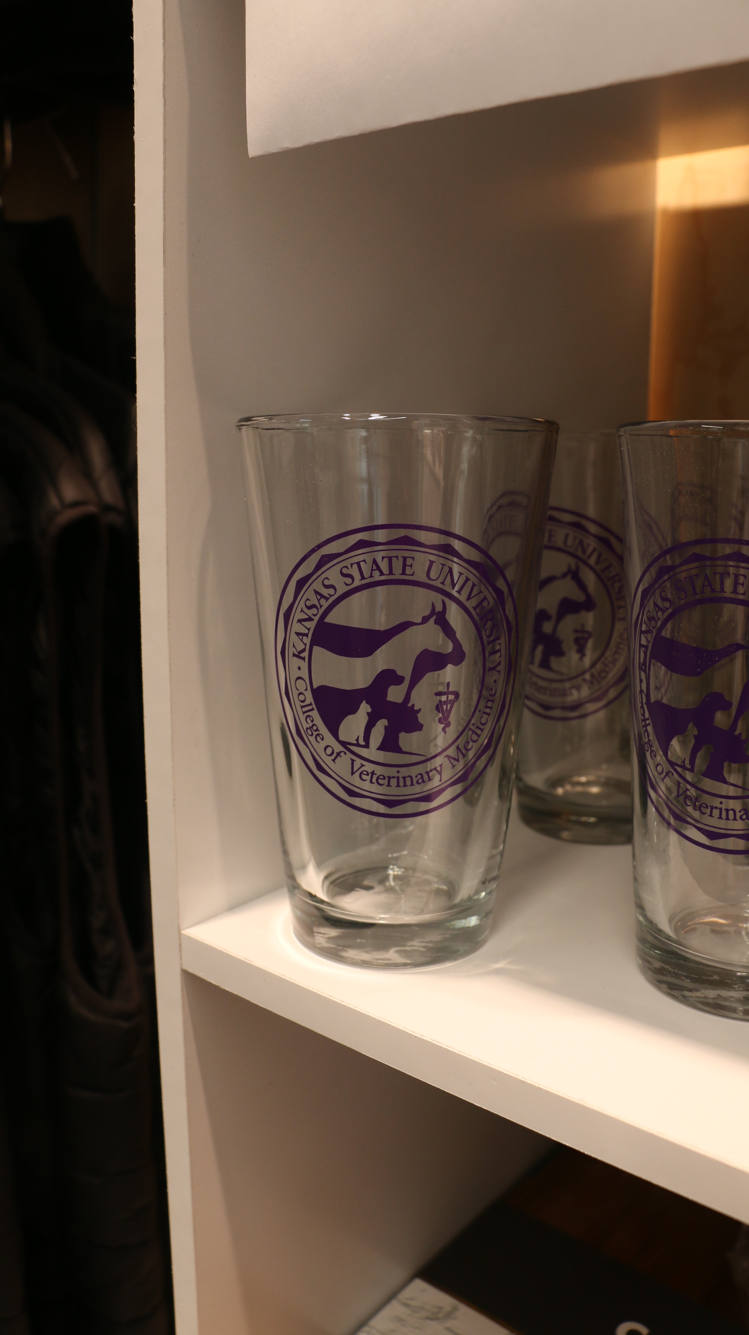 A set of clear executive pint glasses with the purple CVM seal in the center. 