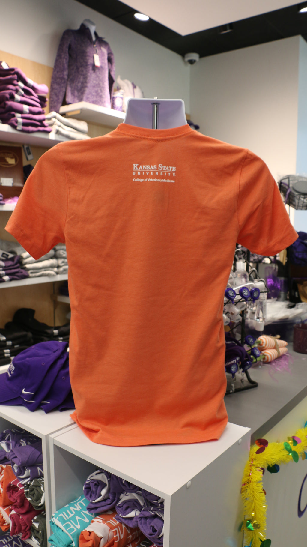 A rear view of the shirt that has a white K-State College of Veterinary Medicine logo on the upper middle back area. 