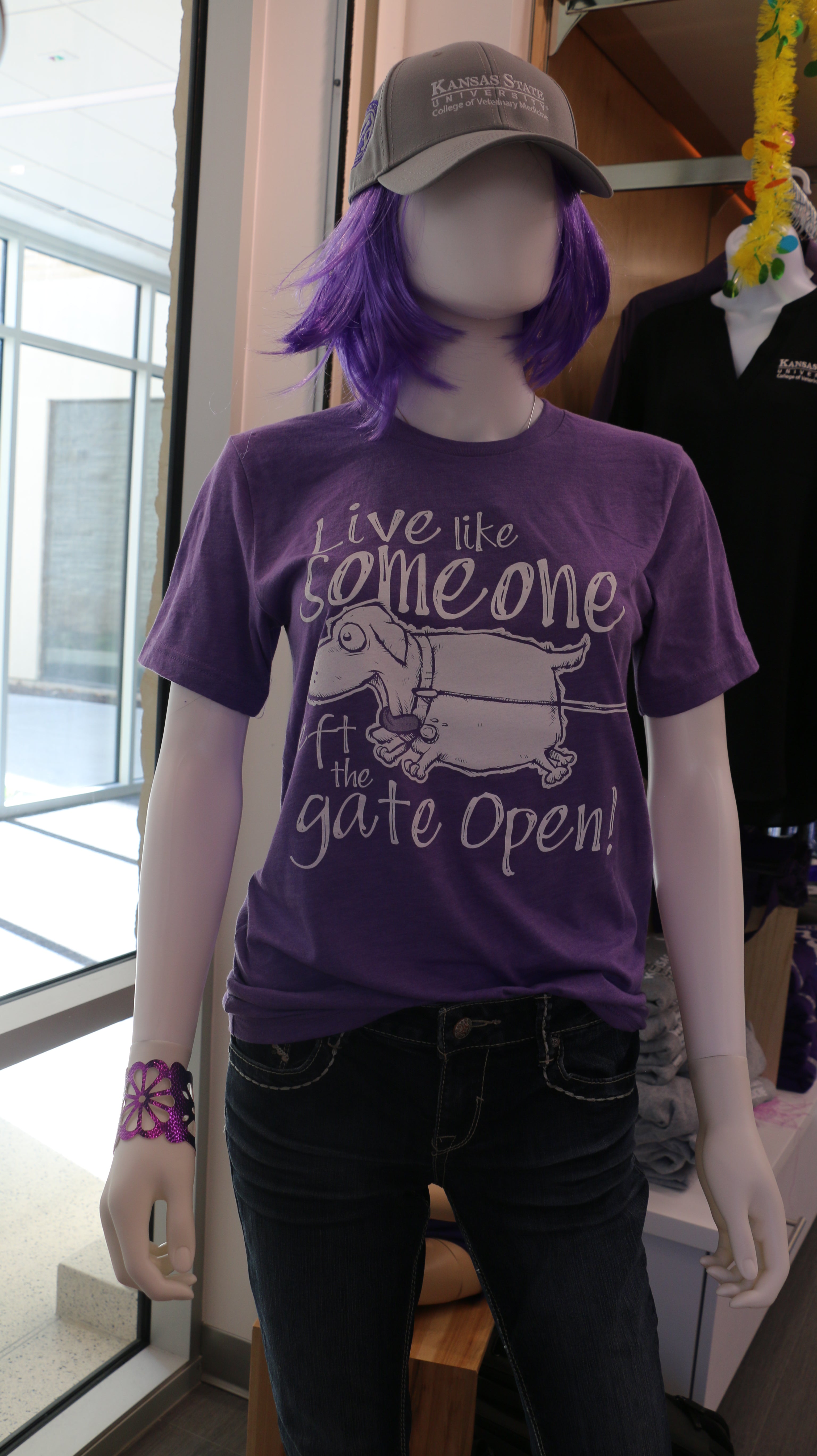 Dark purple Bella Canvas t-shirt with white text that reads "Live like someone left the gate open!" with a dog illustration on the front.
