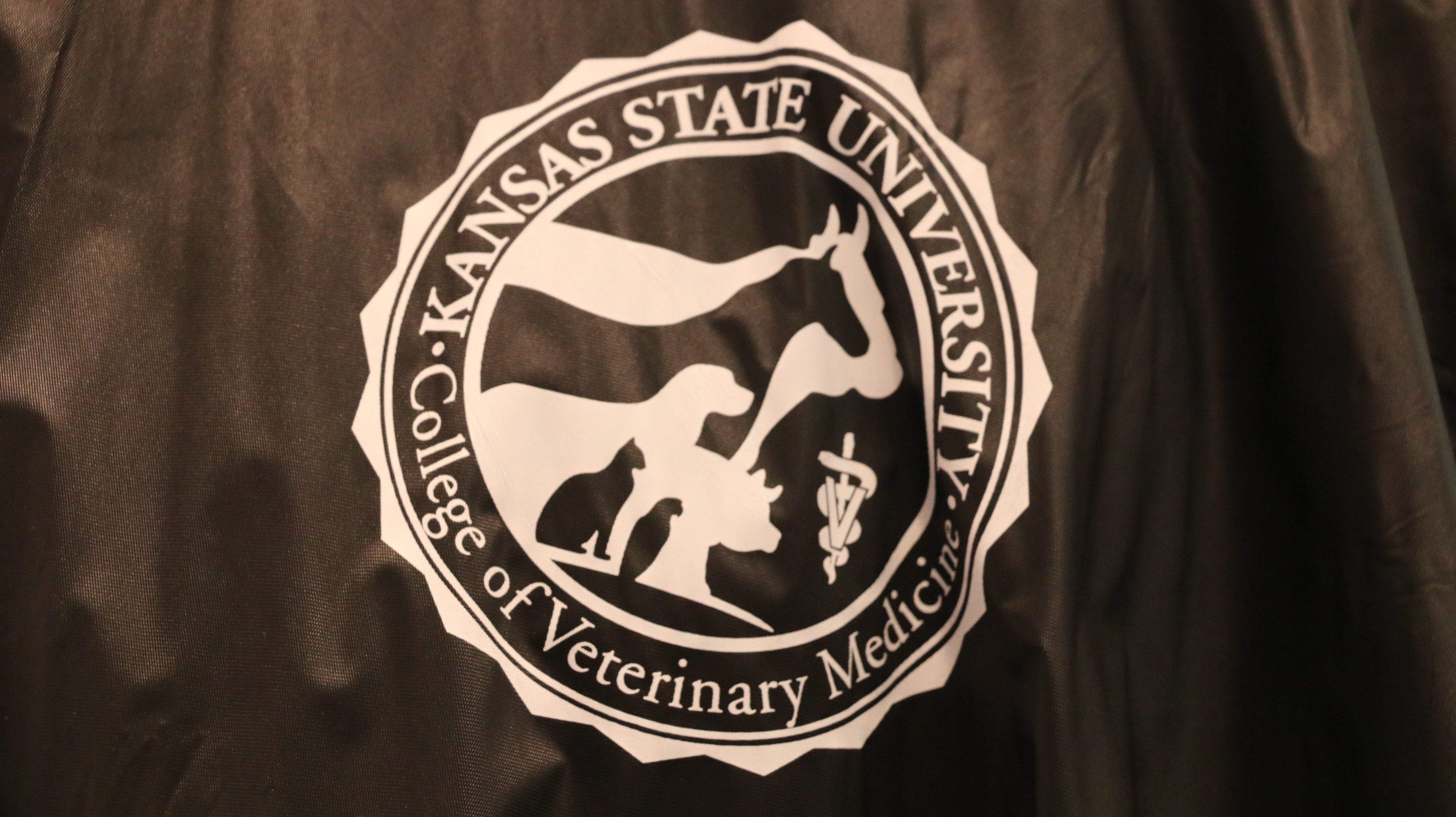 A close-up view of the white CVM logo on the upper left chest area. 
