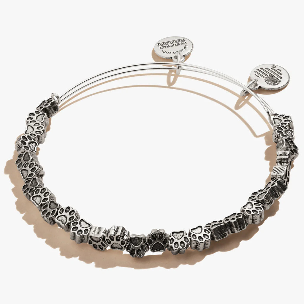 A silver-colored bangle bracelet featuring multiple mini paw charms. 