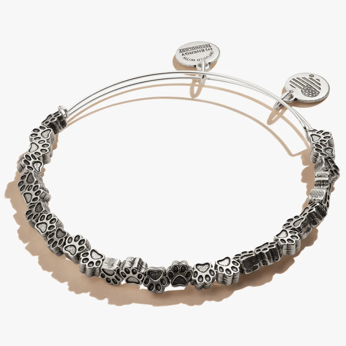 A silver-colored bangle bracelet featuring multiple mini paw charms. 