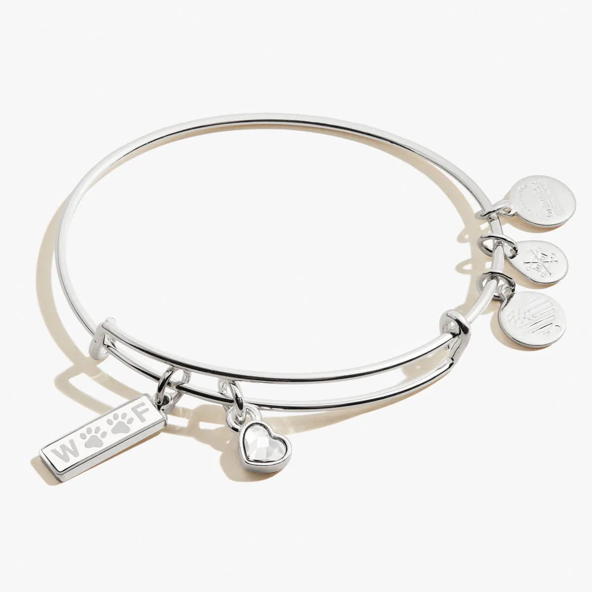 A silver-colored bangle bracelet featuring a small heart and a "woof" charm with paws for Os. 