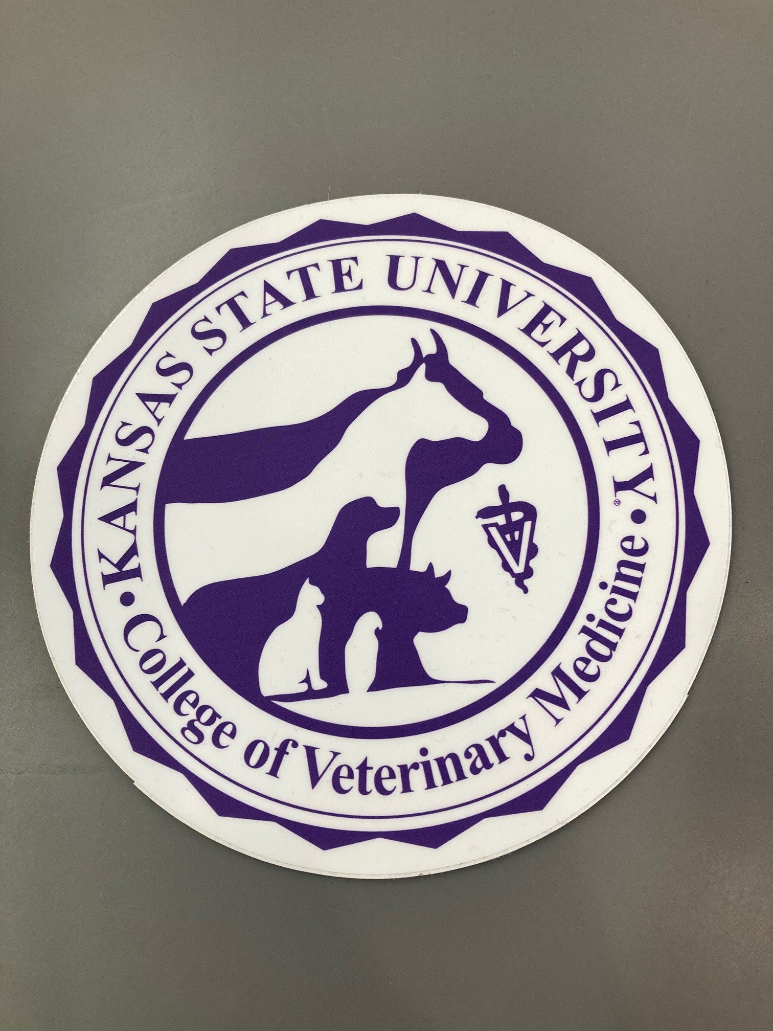 A round sticker with a purple and white color scheme featuring the K-State College of Veterinary Medicine logo.