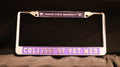 A metal license plate holder with 'Kansas State University' and 'College of Vet Med' embossed on it, in silver and purple color scheme.