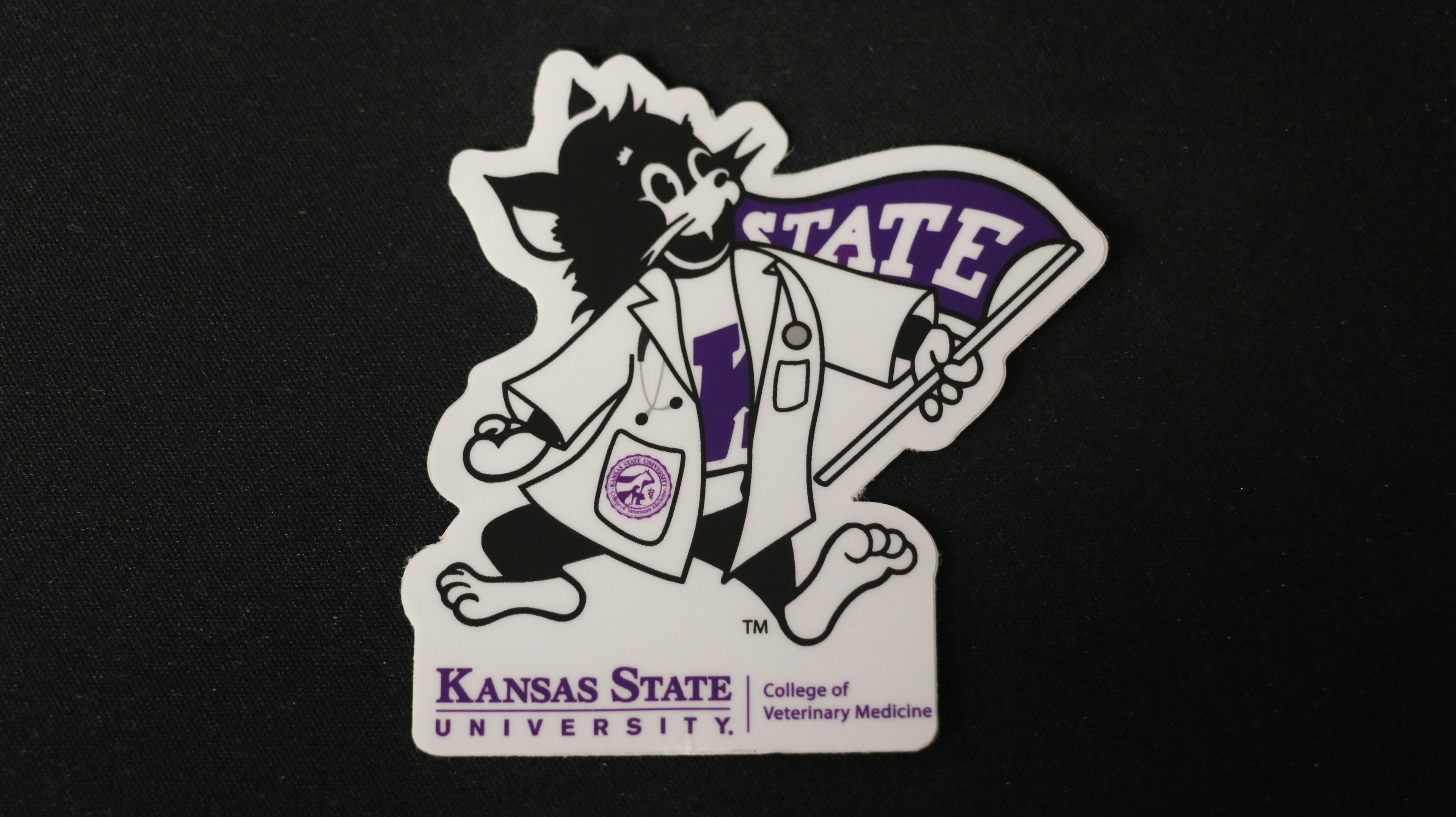 A sticker depicting Labcoat Willie, with a purple coloring and the Kansas State University logo.