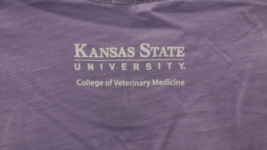 A rear view of the white CVM lettering on the upper middle bac of the shirt. 