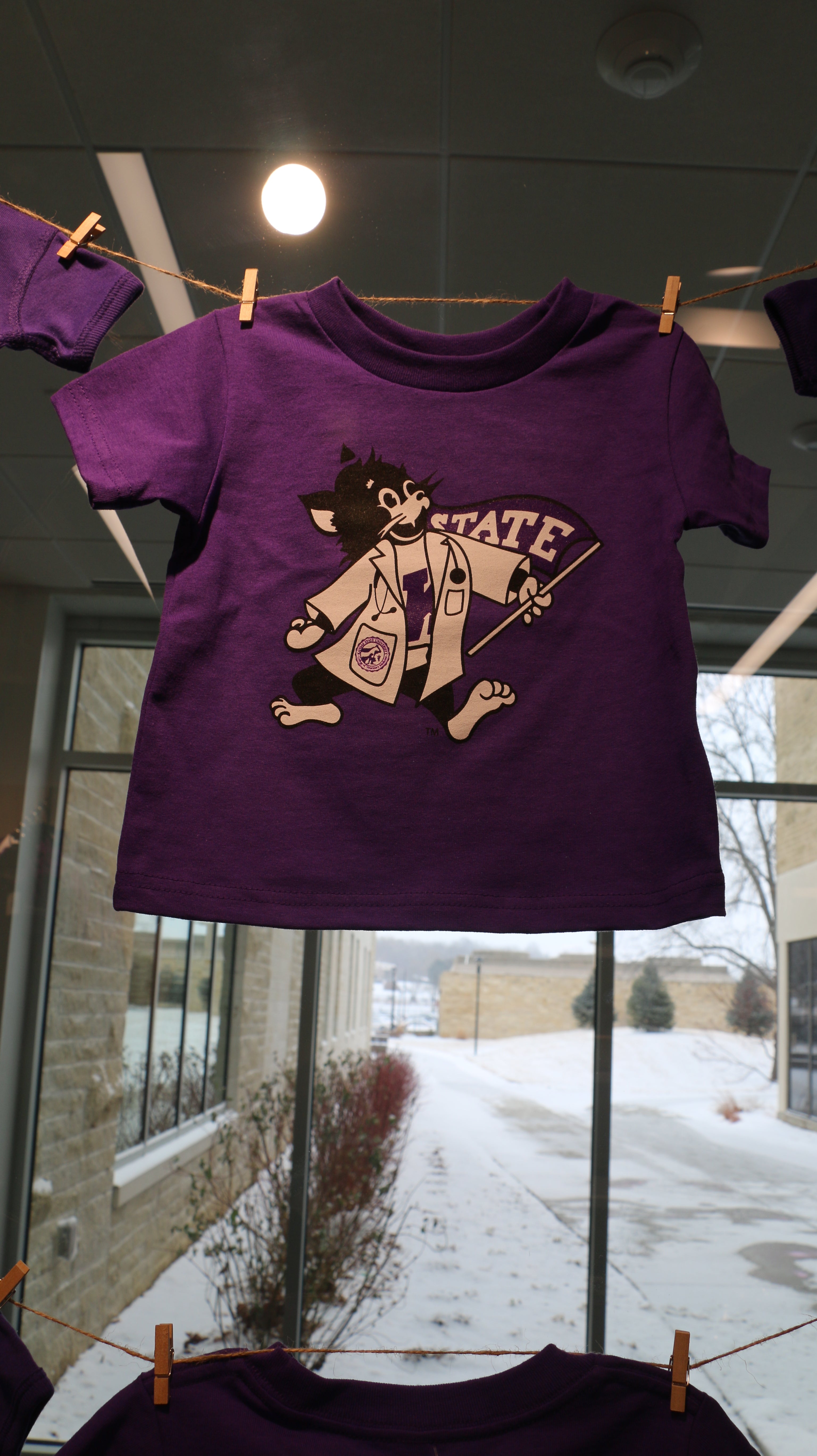 A purple short sleeve toddler T-shirt with a graphic print of Labcoat Willie on it, displayed on a hanger.