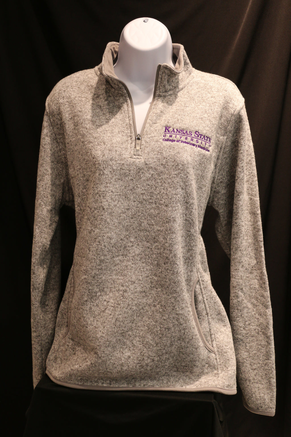Heathered grey ladies quarter zip sweatshirt with side pockets and white CVM logo on the left chest area.
