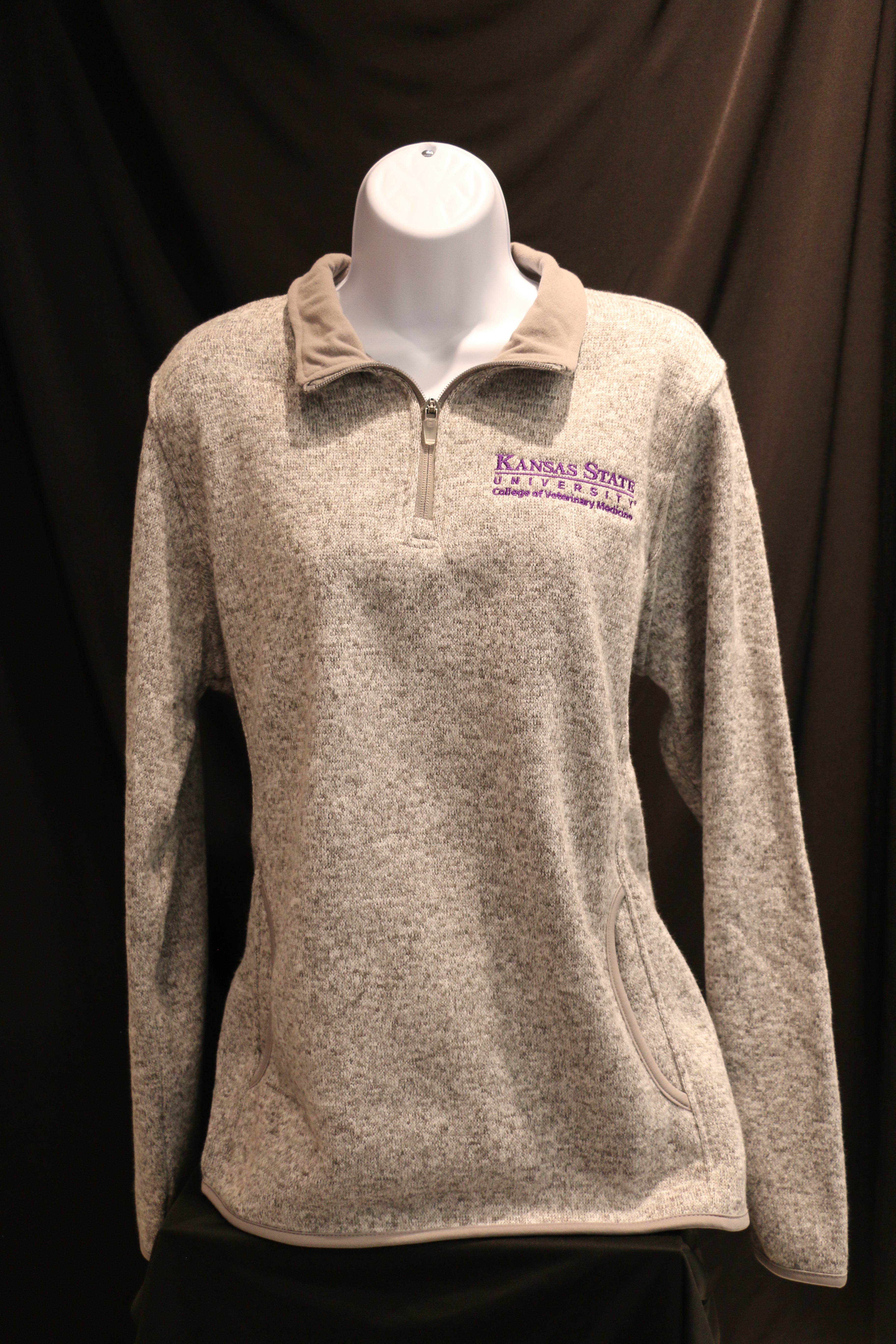 Heathered grey ladies quarter zip sweatshirt with side pockets and white CVM logo on the left chest area.