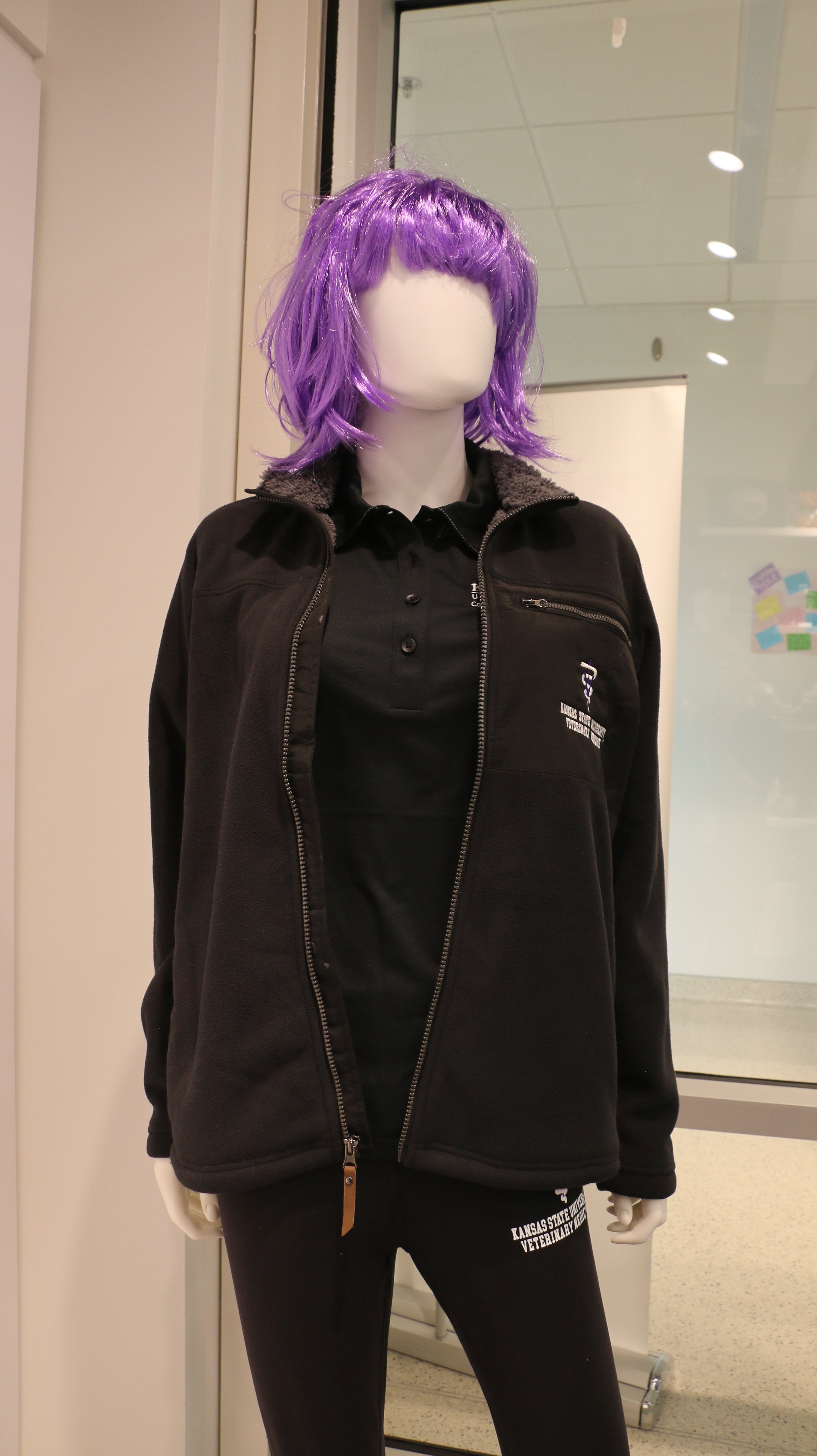 A mannequin wearing a zip up black fleece jacket with quilted details and sherpa lining.