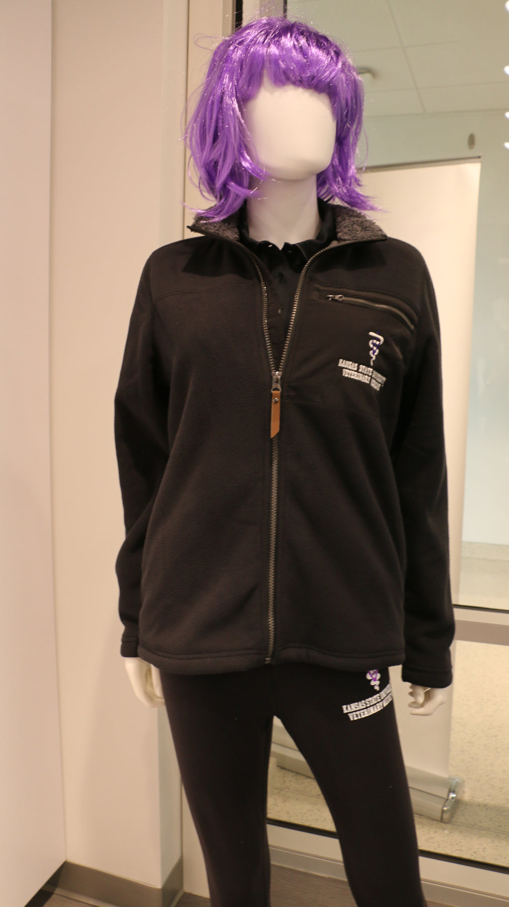 A mannequin wearing a zip up black fleece jacket with quilted details and sherpa lining.
