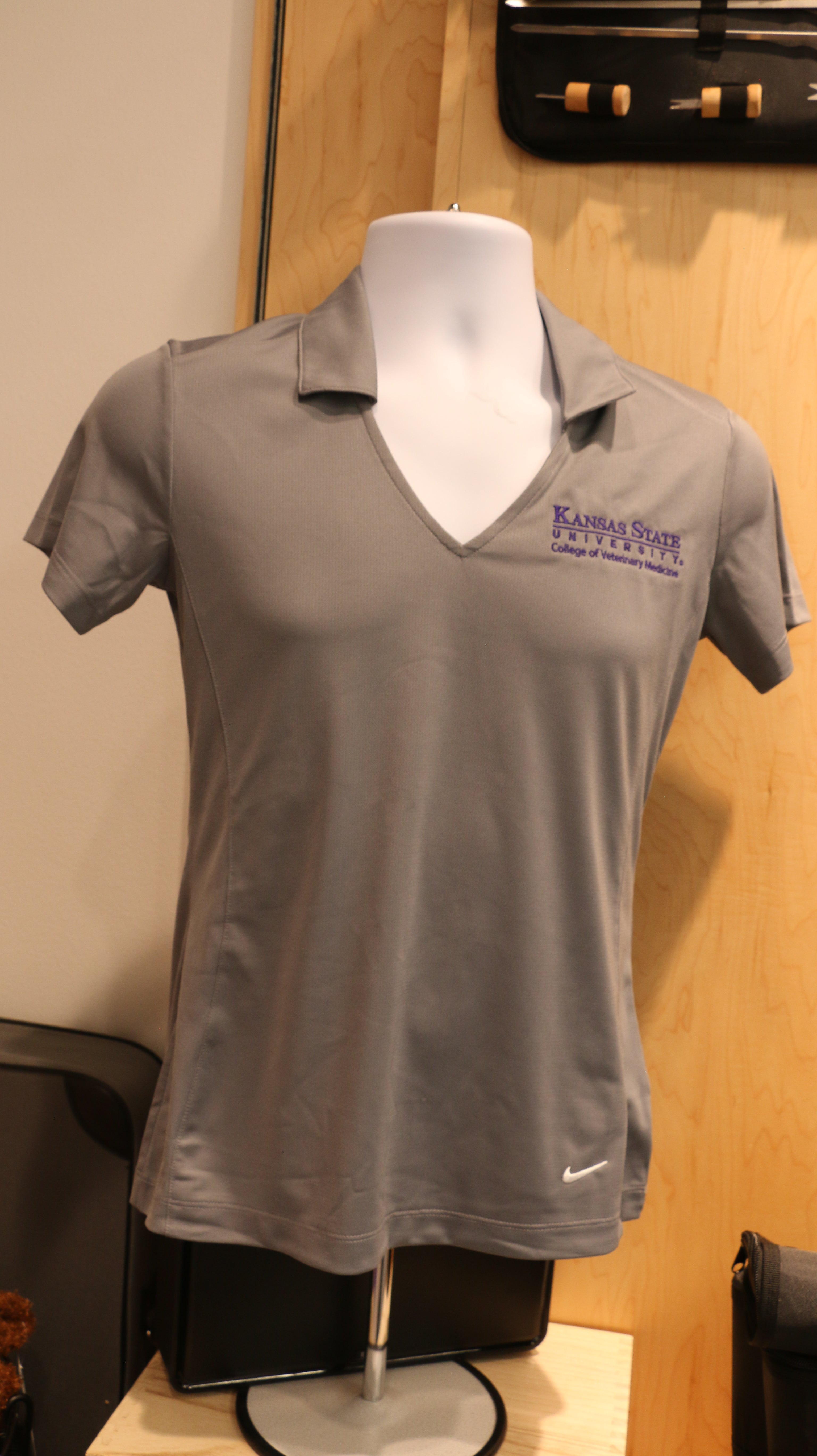 A light gray Nike Golf Dri-Fit Mesh Polo shirt with purple embroidery on a mannequin. 