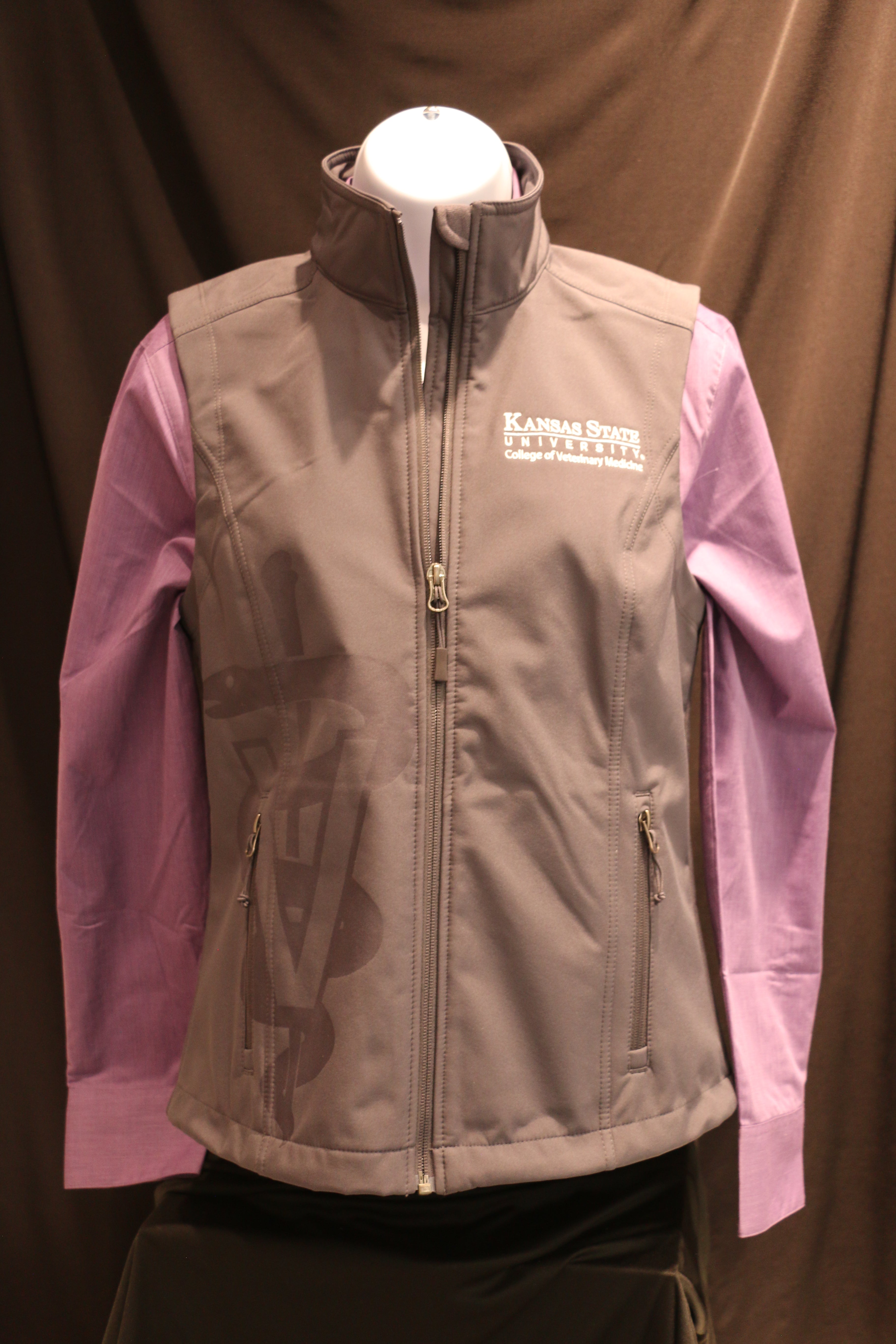 A gray Port Authority lightweight vest for ladies featuring laser caduceus etching, side zip pockets, white CVM logo, and displayed with a purple shirt underneath.