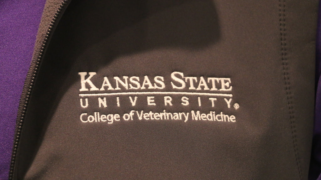 A close-up of the white CVM logo on the upper left chest area. 