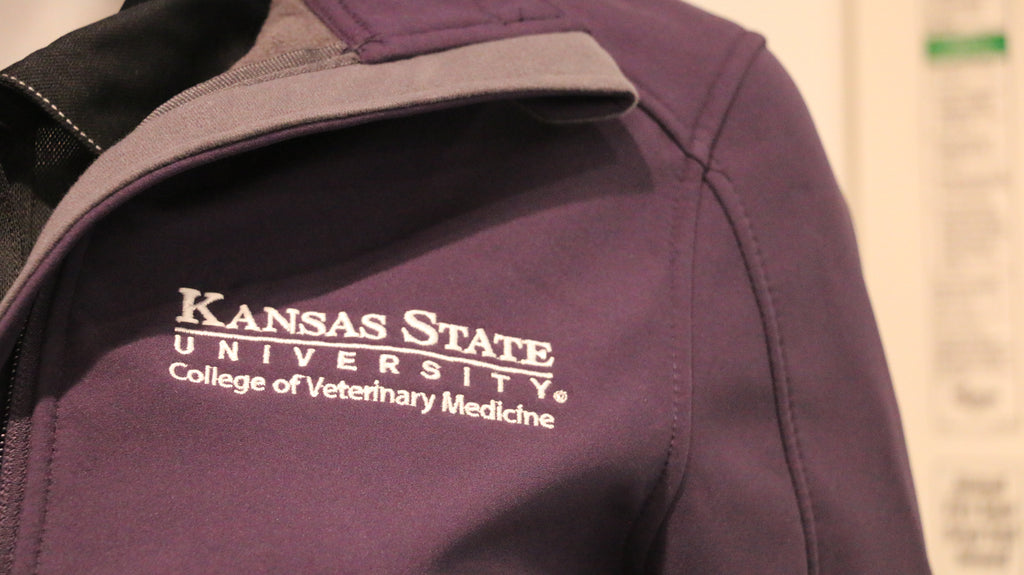 A close-up view of the white CVM logo on the upper left chest area. 