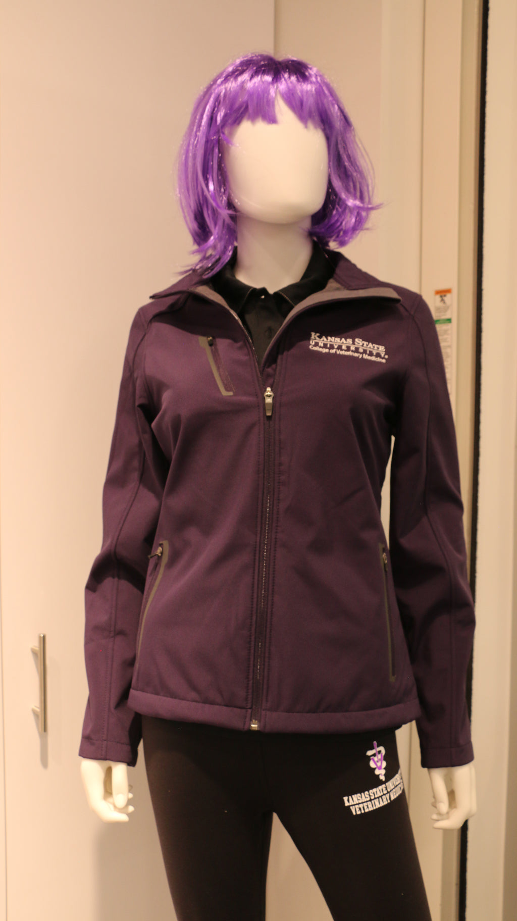 A purple Port Authority soft shell zip up jacket with side zip pockets, white CVM logo, and displayed on a mannequin.
