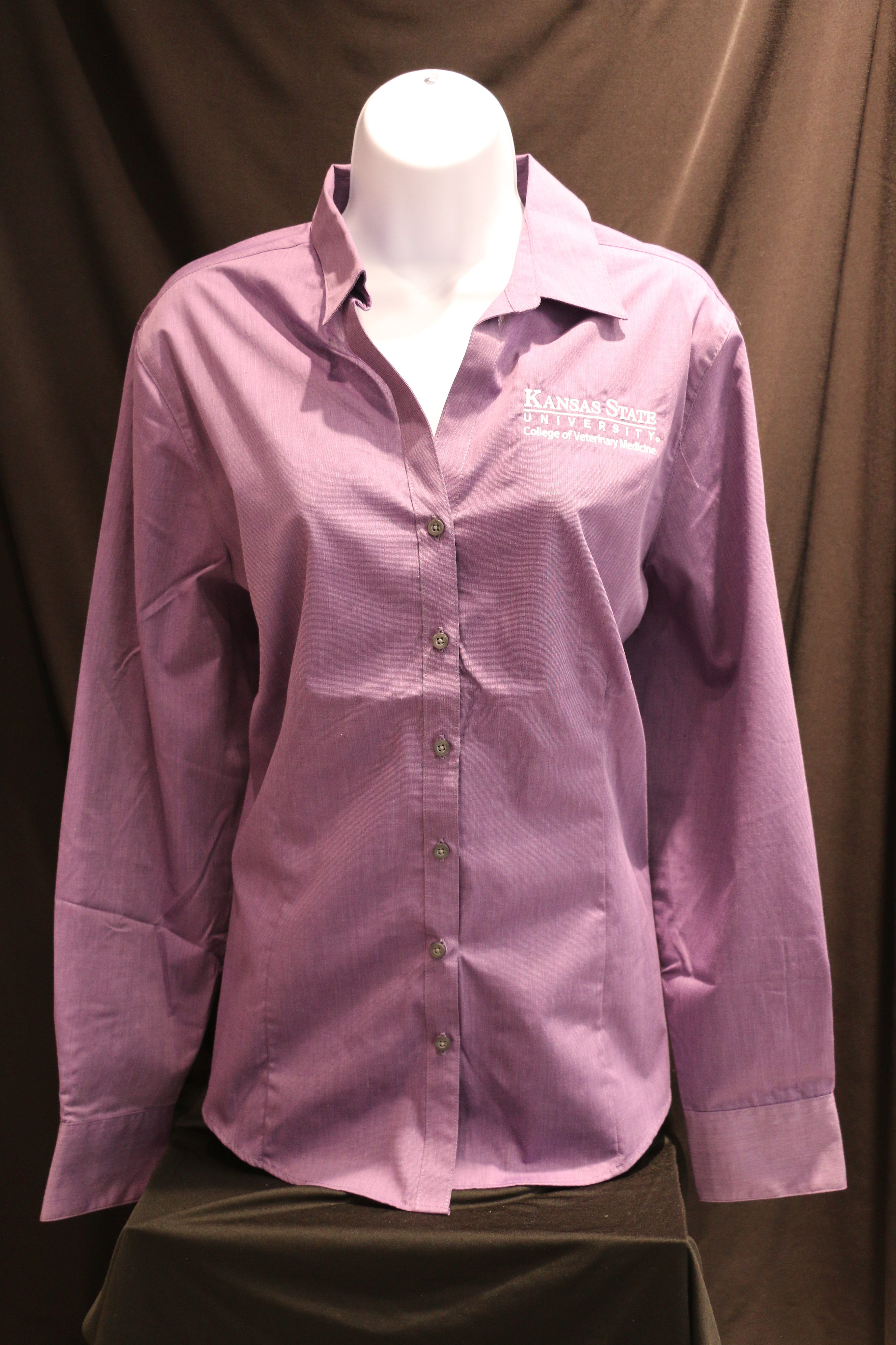 A customized Port Authority Purple Woven long sleeve button up dress shirt viewed from the front with a white Kansas State University seal. 